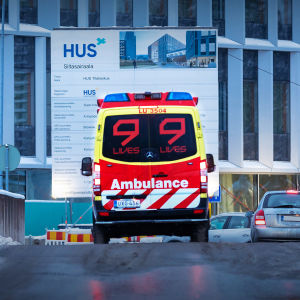 Ambulans utanför Brosjukhuset i Mejlans i Helsingfors. Det finns snö på marken.