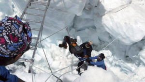 Här räddas en bergsbestigare av sherpor Mount Everest.