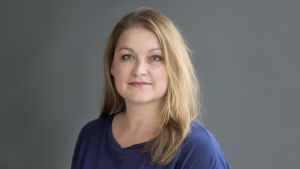 Tytti Oras är jurist på Journalistförbundet. En porträttbild av tytti oras. hon bär blå klädsel och bakgrunden är i en mörkgrå ton.