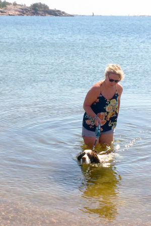 Hunden Sampo är Sigrid Sundells ögonsten i en vardag kantad av psykisk ohälsa. Sigrid Sundell med hund i vattnet.