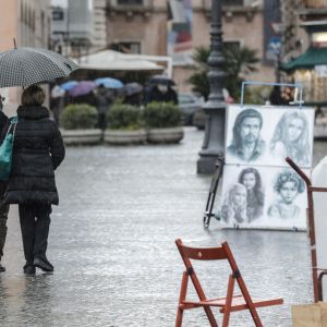 Ett påar promenerar i regnet i Rom