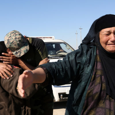 En irakisk polis kramar sin mor som nyss har flytt den befriade förorten Gagjali öster om Mosul.