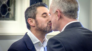 Kaksi miestä suutelee toisiaan