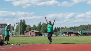 Pirjo Saukkonen tuulettaa voittoheittoaan. nainen nostaa kätensä ilmaan heittonsa jälkeen urheilukentällä.