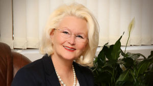 Saila Rosas är vd för Västra-Kymmene Andelsbank. Banken har också kontor i Lappträsk, Elimä och Koria. Kvinna med pärlhalsband