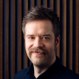 "Det är en relativt låg nivå på ljuden, så det påverkar mest i bilens närhet", säger Fredrik Hagman om de nya elbilsljuden. Vit man med mustasch ler mot kameran.