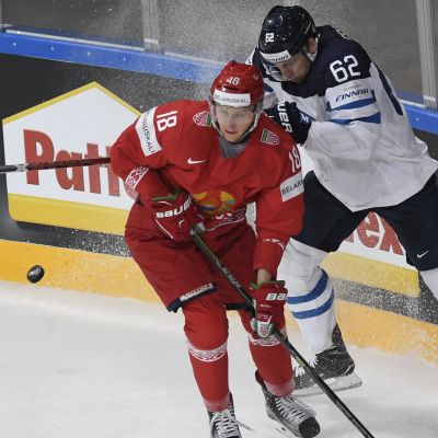 Osala och en vitrysk spelare kämpar om pucken.