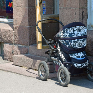 Barnvagn på gatan utanför affär.