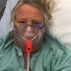 Eva timmarna innan hon åkte in på intensiven. Här bär hon en vanlig syremask Eva Liljelund-Mattsson tittar in i kameran med en syremask framför näsan.