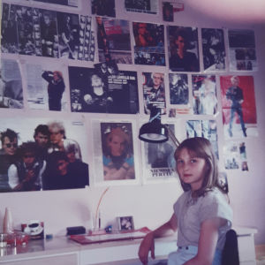 Minna päätyi sattumalta Dingon keikalle v.1985: "Hurmoksen voimakkuus oli käsittämätön kokemus" Tyttö kirjoituspöydän äärellä, seinällä kuvia Dingosta.