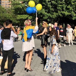 Nationaliteten går knappast att ta miste på. Ung kvinnar hälsar med svenska färger på ballonger och flaggor.