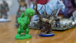Figuren till höger såg exakt ut som den gröna figuren innan Martin började fixa till den. Plastmodeller i miniatyr som föreställer fantasifigurer med hammare och yxa.
