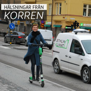 En glad kvinna åker ett elrullbräde på en gata. På bilden är också texten "hälsningar från korren".