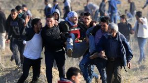 Palestinska demonstranter bar en sårad kamrat efter sammandrabbningar med israeliska säkerhetsstyrkor, nära gränsstängslet mot Israel öster om Gaza City på fredagen. Palestinska demonstranter bar en sårad kamrat i sammandrabbningar med israeliska säkerhetsstyrkor nära gränsstängslet mot Israel öster om Gaza City på fredagen.