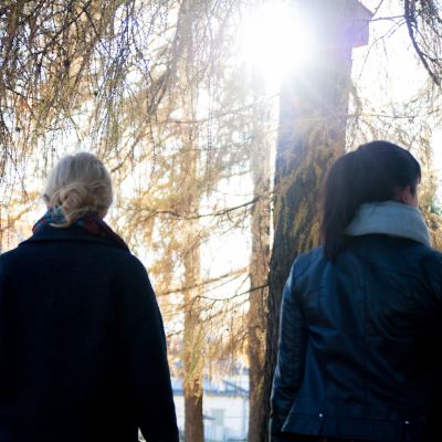 Kaksi naista kävelee puistossa.