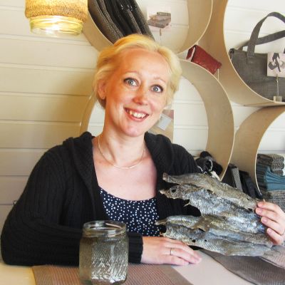 Kuvassa kalannahkoista käsitöitä tekevä Satu Somero.