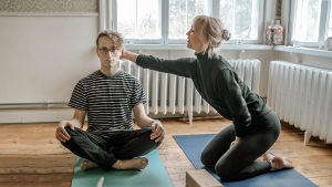 Matilda Mannström berättar om yoga. Matilda Mannström och Axel Åhman yogar.