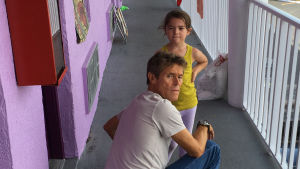 Dafoe i The Florida Project. Bobby (Willem Dafoe) på knä framför Moonee (Brooklynn Prince) vid huset där de bor.