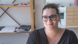 Mira-Veera Auer fick allvarliga symptom av inomhusluften i sin lägenhet. Heka frågade henne om problemen kunde bero på pollenallergi trots att symptomen börjat på vintern. En kvinna med förväntansfull blick. Hon sitter på en stol i en lägenheten.