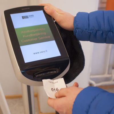 Mies ottaa vuoronumeron Verovirastossa.