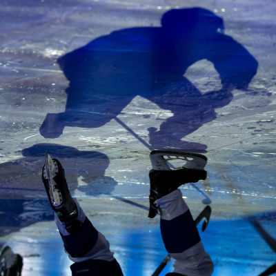Skugga av ishockeyspelare på is.