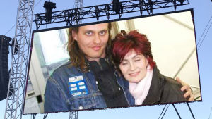 Skribenten och Sharon på Ozzfest i England 2002. Lasse Grönroos och Sharon Osbourne poserar tillsammans på Ozzfest i England 2002. Fotot inklippt på Rockfests stora skärm.