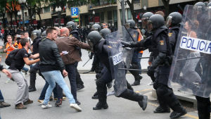 Spaniens nationella polis och väljare drabbar samman utanför en vallokal i en skola i staden Tarragona. Spaniens nationella polis och väljare drabbar samman utanför en vallokal i en skola i staden Tarragona.