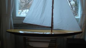 En miniatyr av en segelbåt, byggd av Annas farfarsfar, restaurerad av Anna. en miniatyrbåt, segelbåt i ett vardagsrum