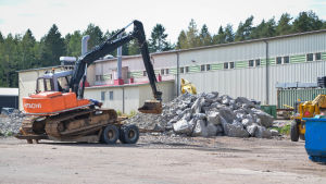Grävmaskiner arbetar för att utvidga platsen så att nya företag kan flytta in till hamnen. Grävmaskin vid Trålhamen i Valkom Lovisa.