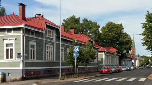 Stadsdelen Port Arthur i Åbo. Vy längs Trädgårdsgatan i Åbo, med ett grönt trähus och Mikaelskyrkan i bakgrunden.