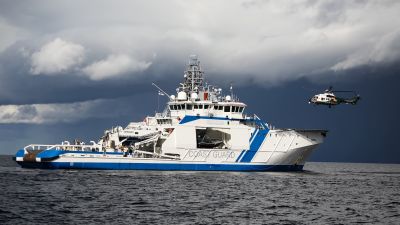 Räddningshelikopter landar på en patrullbåt ute till havs.
