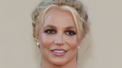 Britney Spears tittar åt sidan och ler på röda mattan.