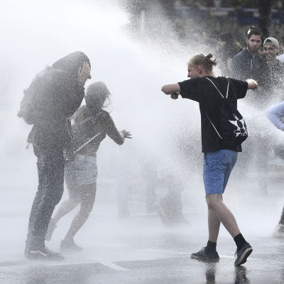 Polisen sprutar vatten på demonstranter. 
