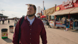 Inte längre i armén. Regissören Joonas Berghäll spelar själv en central roll i filmen. Jonnas Berghäll promenerar på en strandpromenad utomlands.