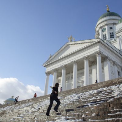 Kvinna springer upp för trappan till Helsingfors domkyrka