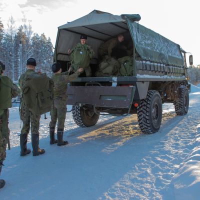Varusmiehet pakkaavat reppuja Masi maastoautoon