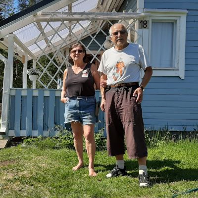Nainen ja mies seisovat siirtolapuutarhan edustalla.