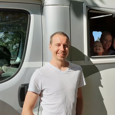 Mies ja lapset asuntoautossa.