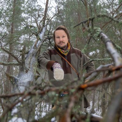 Taiteilija Niillas Holmberg metsässä.