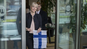 Sannfinländaren Huhtasaari flaggar för nationalstaten. Laura Huhtasaari med en Finlands flagga i handen.