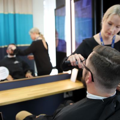Partamuotoilija siistii asiakkaansa partaa.