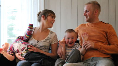 Tanja och Mathias Forsblom sitter med barnen i soffan.