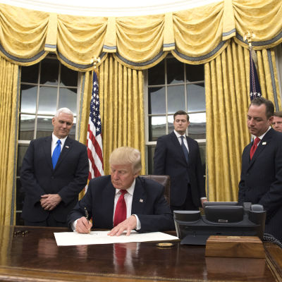 Trump undertecknar sitt första presidentdekret i Ovala rummet.