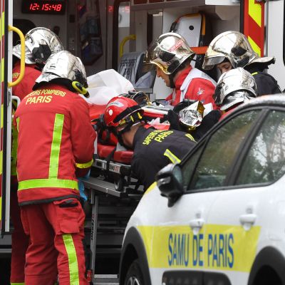 Räddningspersonal lyfter en en sjukhusbår i ambulansen i Paris.