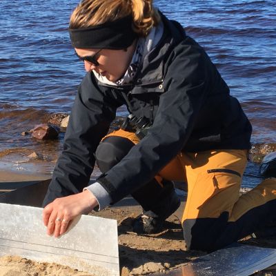 WWF:n meriasiantuntija Anna Soirinsuo kerää näytteitä Nallikarin hiekkarannalla mikromuovin määrän selvittämiseksi.
