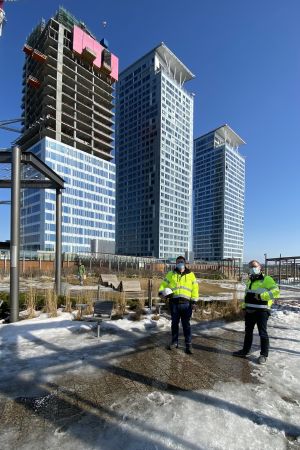 Det finns flera hundra bostäder i varje skyskrapa. Byggarbetarna har hunnit få fasaden på plats på Lumo Ones sjuttonde våning. Kai Remmler och Kim Jolkkonen poserar framför skyskraporna i Fiskehamnen.