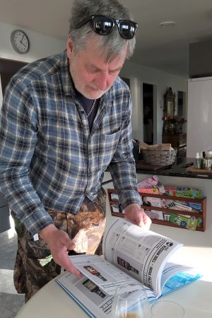 Robert Hägg bläddrar i en bok med ölrecept. Medelålders man bläddrar i en tjock bok.