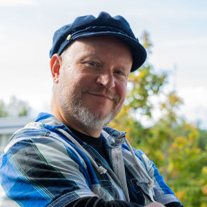 Ohjaaja-käsikirjoittaja Mikko Kaukolampi Mikko Kaukolampi hymyilee ulkona kameralle kädet puuskassa.