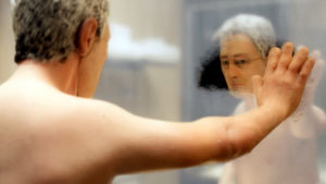 Michael Stone, nukkeanimaatioelokuvan Anomalisa päähenkilö, katselee apeana itseään huuruisesta kylpyhuoneen peilistä.