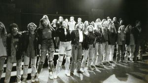 Dajju Biznes var den första stora musikalen. Ungdomar i en musikal står rad på scenen.